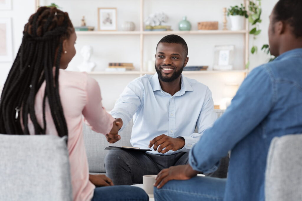 family-counselor-shaking-hands-with-happy-couple